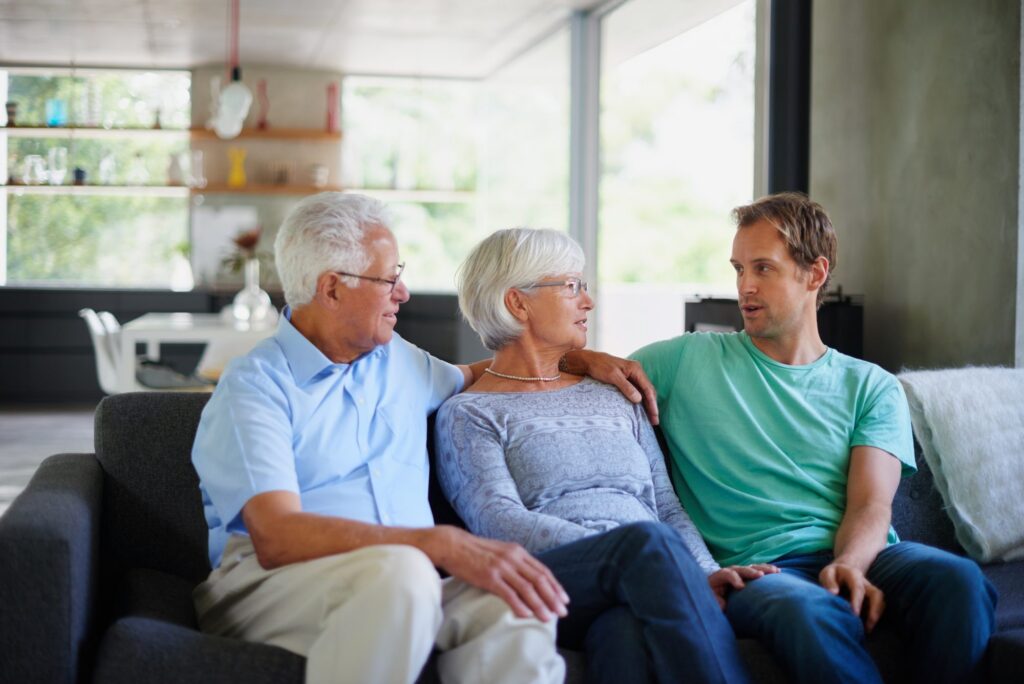 Man sitting with senior parents discussing estate and wills and needing to contact Western Springs Estate Planning Attorney.