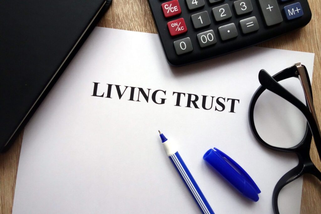 Document titled "Living Trust" rests on a table alongside a pen, glasses, calculator, and notebook. Essential for LaGrange Park Trusts and guided by Brookfield Elder Law expertise, this setup underscores meticulous estate planning attention to detail.